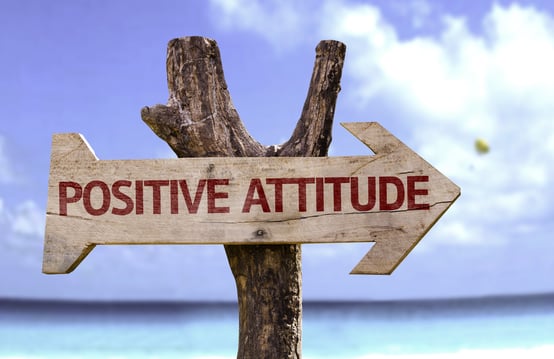 Positive Attitude wooden sign with a beach on background
